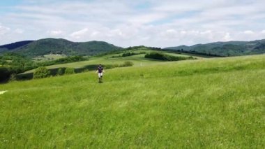 Kahverengi saçlı atlet yaz havasında bir tepenin tepesinde atlama ipinden atlıyor. Dayanıklılık eğitiminden önce ısınıyorum. Kaslarını ısıt. 4k video