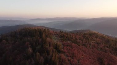 Zborov nad Bystrica kasabası yakınlarındaki Slovak kırsalında gün doğumu manzaralı. Oravsk Magura vadisindeki taş kule. Sabah turuncu yumuşak ışık. İHA atışı