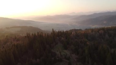 Zborov nad Bystrica kasabası yakınlarındaki Slovak kırsalında gün doğumu manzaralı. Oravsk Magura vadisindeki taş kule. Sabah turuncu yumuşak ışık. İHA atışı