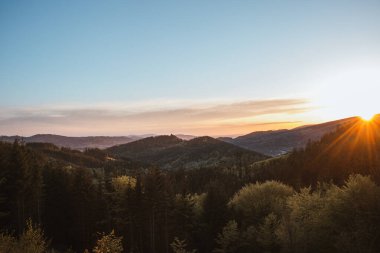 Sunset over the Moravian-Silesian part of the Czech Republic in Beskydy mountains. Orange glow of the sun in the early evening over a mixed forest. Wilderness.
