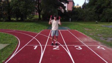 Goal-oriented athlete does lunges with a water booster bag on his back for greater load on the lower limbs. Workout on the workout court.  Aquahit on an athlete. 