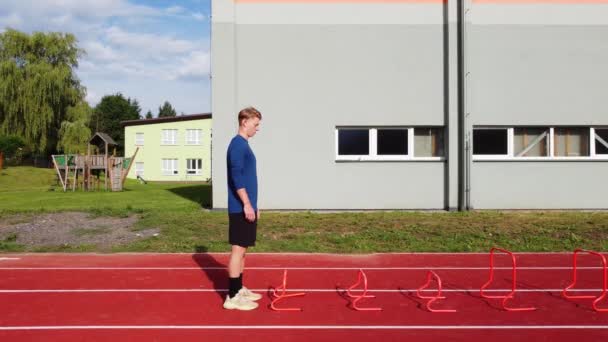 Blond Athlete Blue Shirt Develops His Dynamic Strength Jumping Hurdles — Vídeo de stock
