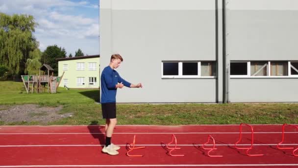 Blond Athlete Blue Shirt Develops His Dynamic Strength Jumping Hurdles — Stockvideo