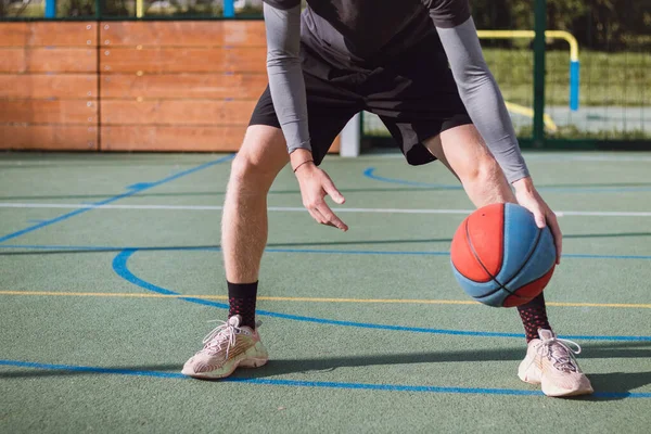 Genç yetenek antrenmanlarında ayaklarının altına basketbol topu sürüyor ve el, vücut ve ayak koordinasyonunu geliştiriyor. Basketbol maçı. Numarayı, aldatmacayı öğrenmek..