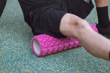 Spor eğitmeni kas gruplarına etkin bir şekilde etki eden masaj rulosunun yardımıyla vücudun alt kısmını çalıştırır ve ısıtır. Femoris kaslarını ısıtıyorum..