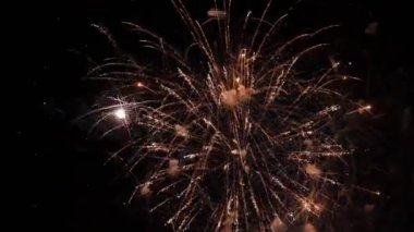 4 bin. Gerçek havai fişek arka planının kusursuz döngüsü. Gece gökyüzünde bokeh ışıkları olan gerçek altın sarısı havai fişeklerin soyut bulanıklığı. Parlak havai fişek gösterisi. Yeni yıl arifesi havai fişek kutlaması. 