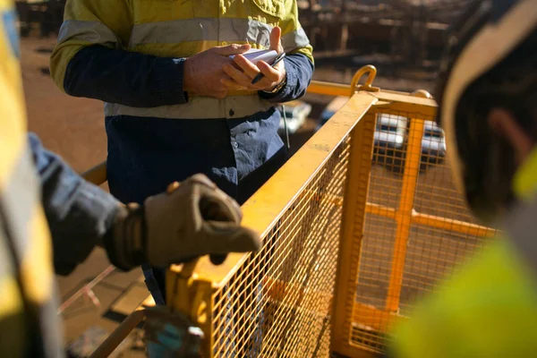 Rope access welder wearing fully safety uniform fall protection helmet, welding glove harness, commencing welding chute repair in confined space construction mine site Perth Pilbara region Australia