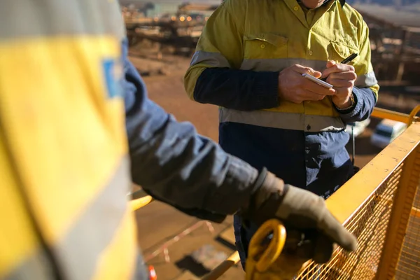 Safety first at work place miner worker conducting personnel risk assessment knowing as take five taking control on note book, construction mine site Perth, Australia