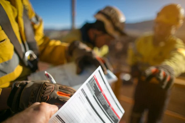 Safety first at work place miner workers wearing a industry safety glove signing of high risk working at height permit on the opening field prior starting early day shift