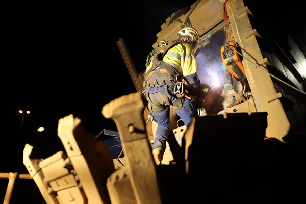 Rope access welder maintenance abseiler wearing fall safety body harness helmet protective equipment abseiling in fall restraint welding repairing reclaimer wheels bucket construction site Perth