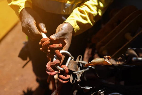 Safety first at work place rope access technician inspector conducting inspecting tension dressing barrel knot on locking Carabiner prior to commencing work abseiling working at heights harness. 