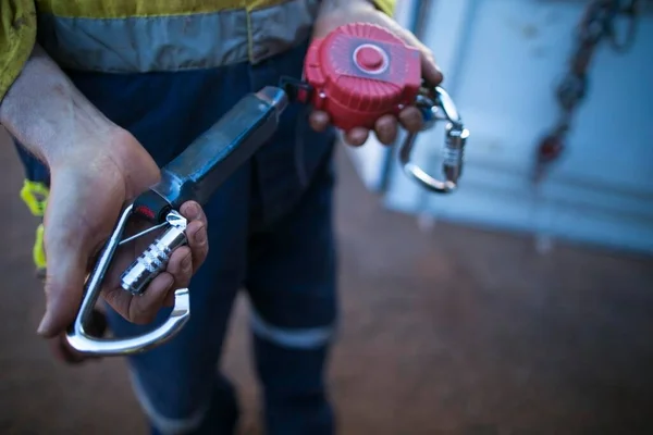 Safety work place trained competent inspector hands conducting testing opening locking carabiner gate which connecting with an inertia reel shock absorbing fall protection device equipment ensuring is working correctly daily inspection prior used 