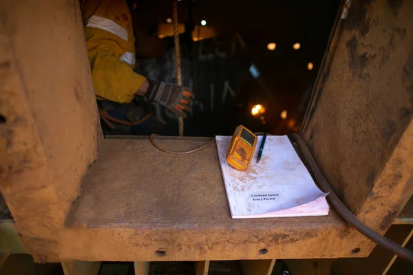 Safety work practices confined space permit book and gas test atmosphere leak detector placing on the entry and exit confined space door continuing monitoring while workers are conducting hot work welding gouging oxygen cutting inside confined space 