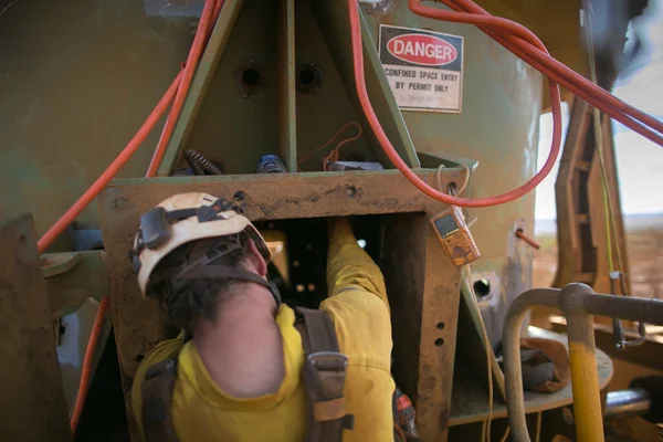 Safety workplace trained confident person miner rope access worker wearing safety harness fall protection side impact helmet entering into confined space construction mine site Perth, Australia 
