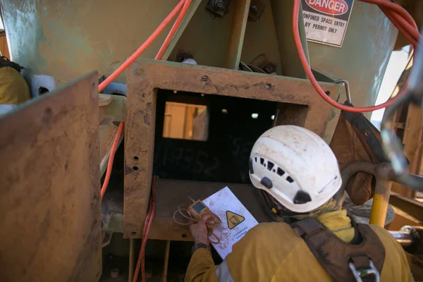 Safety workplace certifies construction supervisor wearing long-sleeve shirt a white safety helmet head protection holding gas test detector confined space permit book inspecting safety environment surrounding before conduct gas testing prior entry