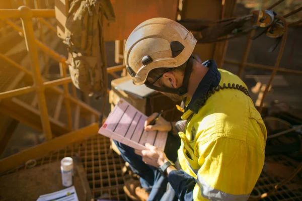 Safety workplace top view of construction supervisor wearing a white safety helmet head protection prior reviewing sign a document and issued the permit work at heights on opening field