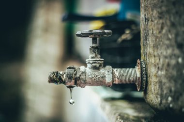 Eski musluktan bir damla su, seçici odaklanma.