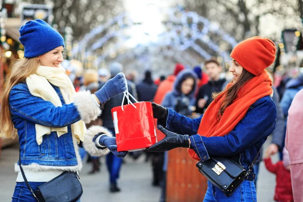 İki kız arkadaş Noel pazarında buluşup birbirlerine hediye veriyorlar. Örgü şapkalar ve atkılar. Sıcak eldivenler. Bir Avrupa şehrinde Noel tatili.