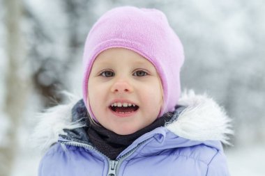 Kış giysileri Sıcak mor ceket ve pembe şapka. Kış tatili.