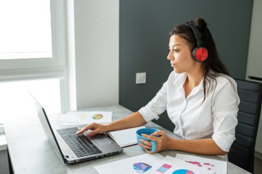 Genç öğrenci çevrimiçi çalışıyor. Ofis çalışanı. Ofiste çalışan bir iş kadını. Uygun bir iş yeri. Uzaktan kumanda. Fazladan para kazan. Para kazanmak. Hobileri nakite çevirmek. Yetenekli bir iş. Tutkuyu işe dönüştürmek. Para ödülleri.