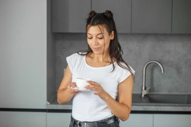 Lezzetli sıcak çayla birlikte beyaz bardak. Modern gri mutfak iç mimarisi. Tatil ve yaşam tarzı kavramı.