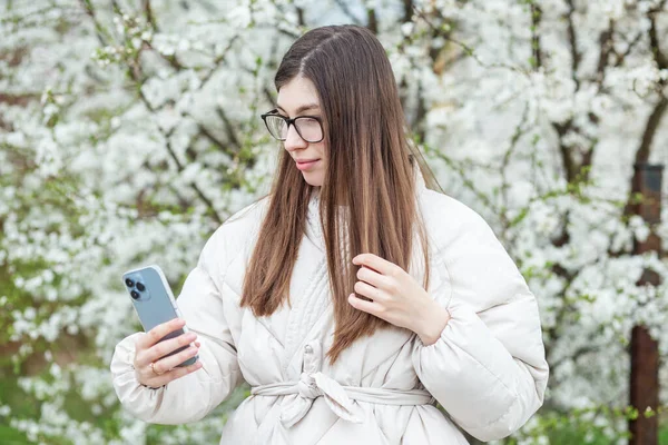 Młoda Dorosła Dziewczyna Czyta Portale Społecznościowe Pomocą Urządzenia Mobilnego Wiosenny — Zdjęcie stockowe