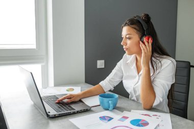 Genç öğrenci çevrimiçi çalışıyor. Ofis çalışanı. Ofiste çalışan bir iş kadını. Uygun bir iş yeri. Uzaktan kumanda. Fazladan para kazan. Para kazanmak. Hobileri nakite çevirmek. Yetenekli bir iş. Tutkuyu işe dönüştürmek. Para ödülleri.