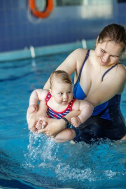 Mutlu anne küçük kızıyla yüzme havuzunda dinleniyor. Dinlenme ve rahatlama.