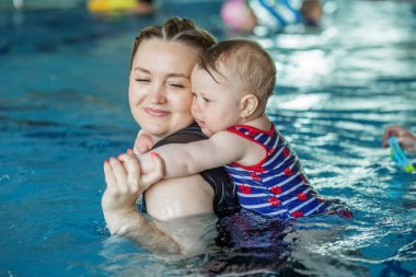 Mutlu anne küçük kızıyla yüzme havuzunda dinleniyor. Dinlenme ve rahatlama.