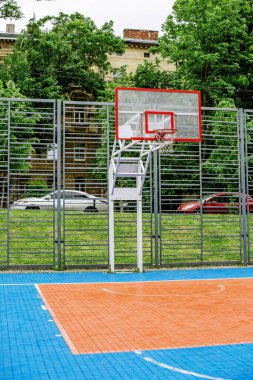 Okulun yakınındaki modern halk basketbol sahasının fotoğrafı. Dikey. Spor anlayışı, hobiler ve sağlıklı yaşam tarzı.