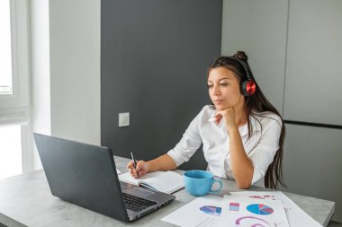 Genç öğrenci çevrimiçi çalışıyor. Ofis çalışanı. Ofiste çalışan bir iş kadını. Uygun bir iş yeri. Uzaktan kumanda. Fazladan para kazan. Para kazanmak. Hobileri nakite çevirmek. Yetenekli bir iş. Tutkuyu işe dönüştürmek. Para ödülleri.
