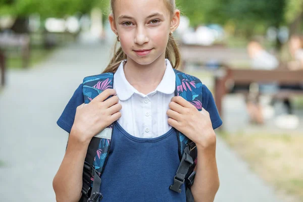 Beautiful teen girl with backpack goes to school. Concept of back to school, education and childhood.