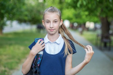 Beautiful teen girl with backpack goes to school. Concept of back to school, education and childhood.