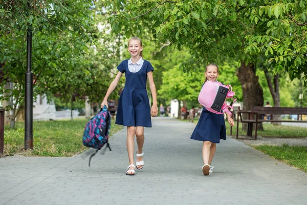 Two Schoolgirls School Throw Backpacks Children Having Fun Concept Back — ストック写真