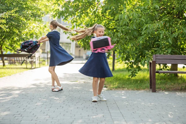 Two Schoolgirls School Throw Backpacks Children Having Fun Concept Back — 스톡 사진