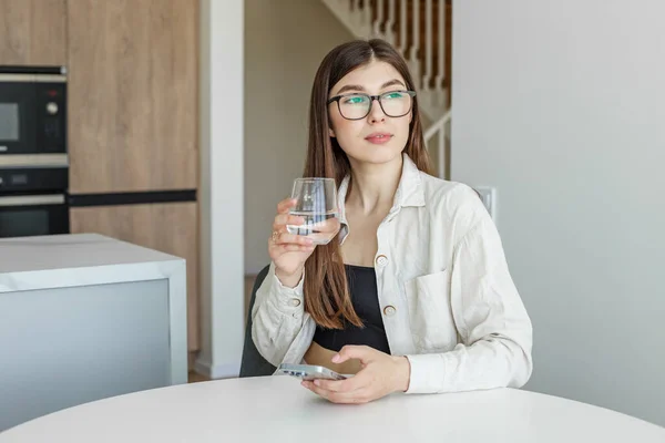 Young Adult Girl Glasses Vision Drinks Water Uses Mobile Phone — Stock Fotó