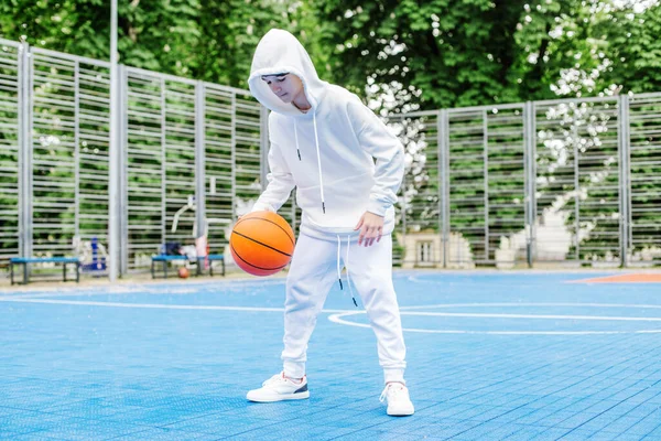 Spor anlayışı, hobiler ve sağlıklı yaşam tarzı. Çocuk okul çocuğu yaz gününde basketbol antrenmanı yapıyor..