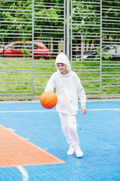 Spor anlayışı, hobiler ve sağlıklı yaşam tarzı. Çocuk okul çocuğu yaz gününde basketbol antrenmanı yapıyor..