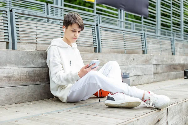 Teenage Boy Uses Smartphone Wireless Headphones Break Basketball Court Concept — Fotografia de Stock
