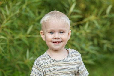 Çizgili tişörtlü gülümseyen çocuk portresi. Yakın plan. Anaokulu, eğitim ve çocukluk kavramı.