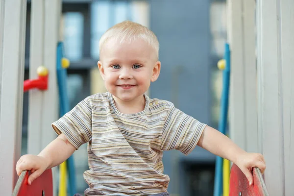 귀여운 살짜리 아이가 여름에 놀이터에서 있습니다 유치원 운동장에서 슬라이드와 스윙을 — 스톡 사진