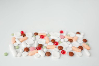 Many different pills on white background. Copy space. Top view. Concept of pharmaceuticals, medicine and healthcare