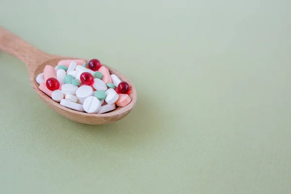 Molte Pillole Diverse Cucchiaio Legno Sfondo Verde Ricevuto Concetto Prodotti — Foto Stock