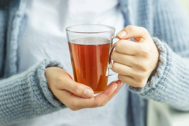 Bir fincan sıcak çay, kadın ellerinde. Geçmişi. İçecek konsepti, yaşam tarzı, sonbahar ve kış. Yatay