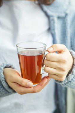 Bir fincan sıcak çay, kadın ellerinde. Geçmişi. İçecek konsepti, yaşam tarzı, sonbahar ve kış. Dikey