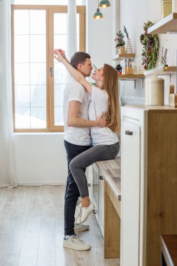Birbirini seven çiftler, sabahları mutfakta birbirlerini öperler. Aile kavramı, sevgi ve rahat ev.