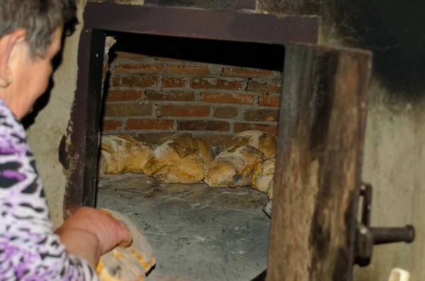 the hands of the chef is cooking in the kitchen. baking bread in a wood oven