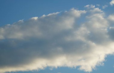 Bulutlar mavi gökyüzünde güneş ışınlarıyla.