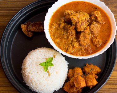 Indian Traditional Cuisine chana dal pakodi or kachri in curry with rice, pakodi and pickle, Bihari khana and thali.