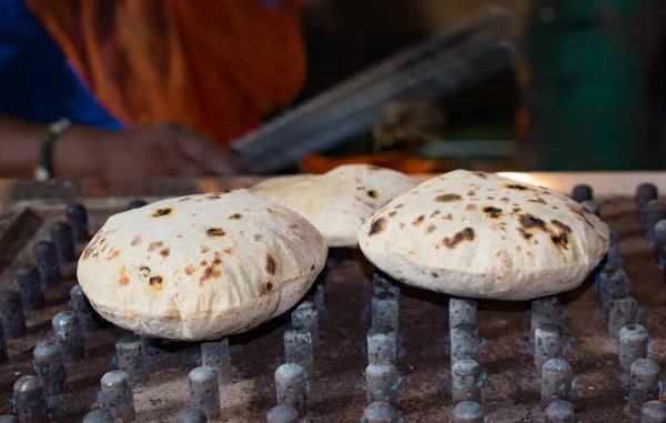 A roti (Indian flatbread) cooking on Indian wedding party. selective focus on one roti, background blur